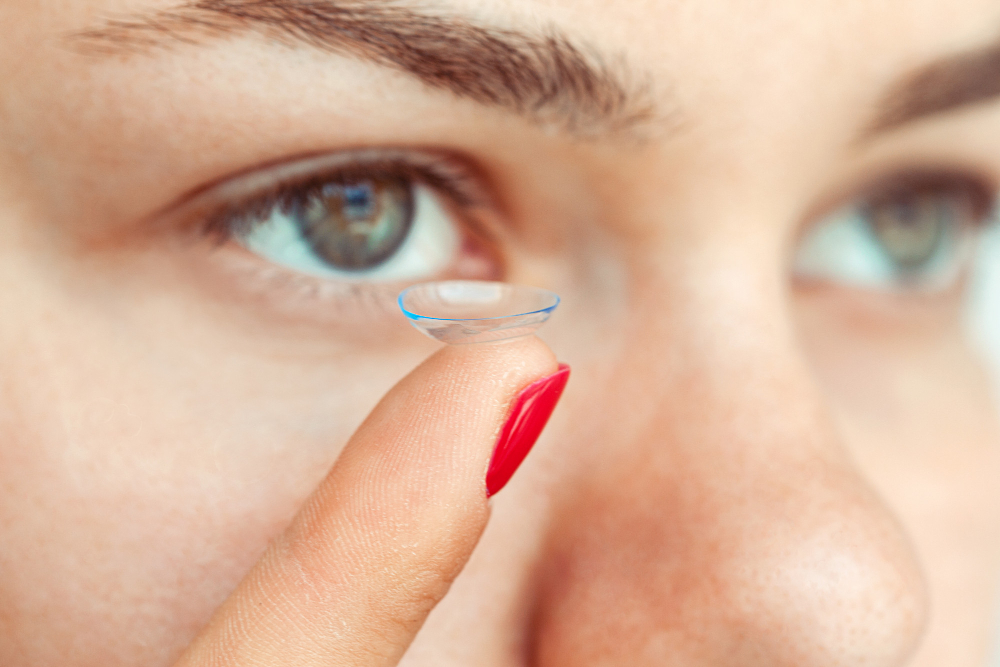 Une femme aux yeux de couleur brun-vert est un train de mettre une lentille de contact