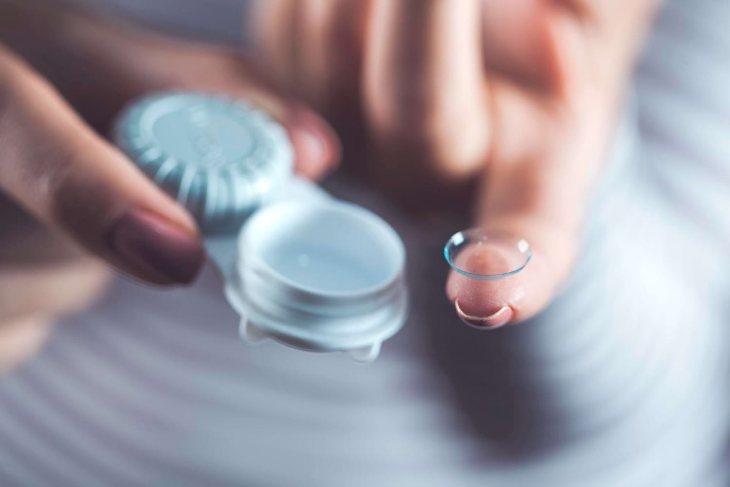 Main de femme tenant un boîtier et une lentille