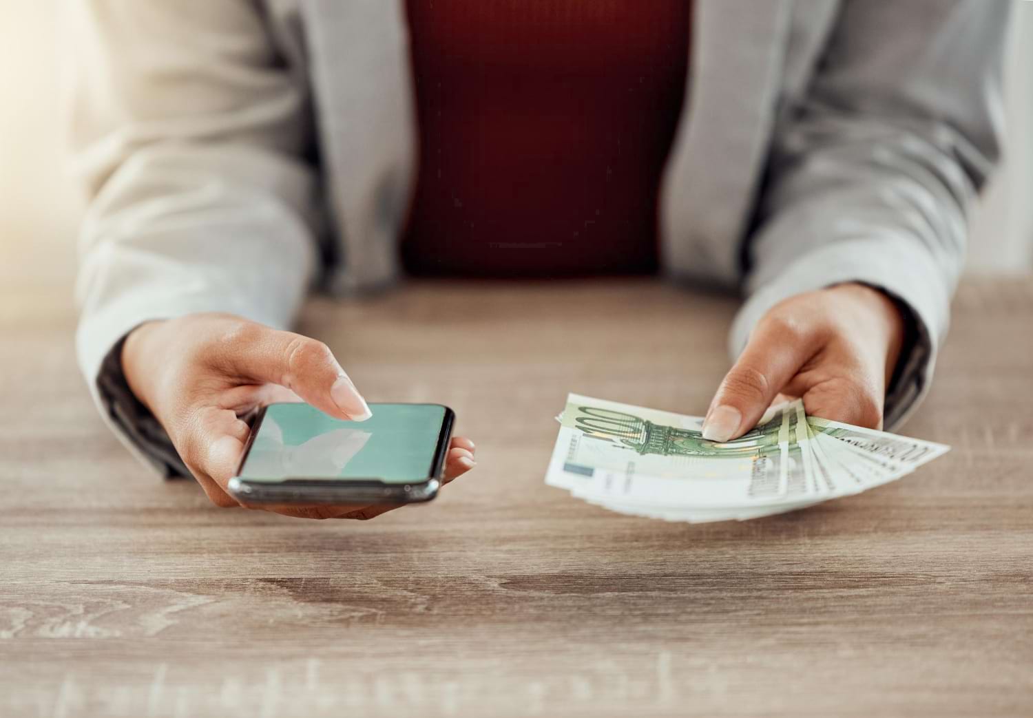 Femme qui tient des billets et un portable