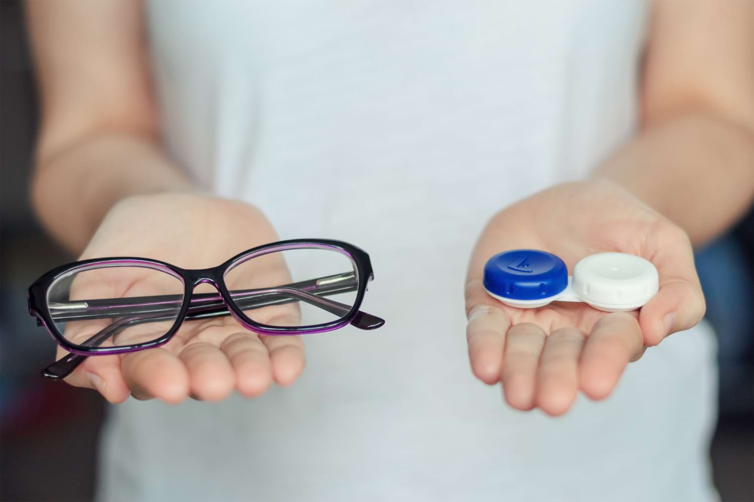 Femme qui tient des lentilles et des lunettes