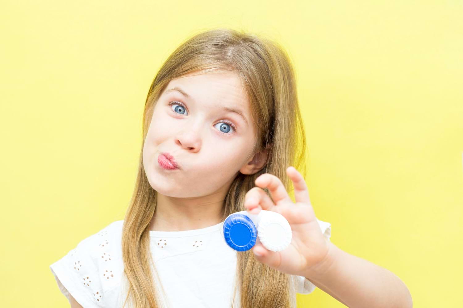 fille aux cheveux longs tient un récipient avec des lentilles à la main.