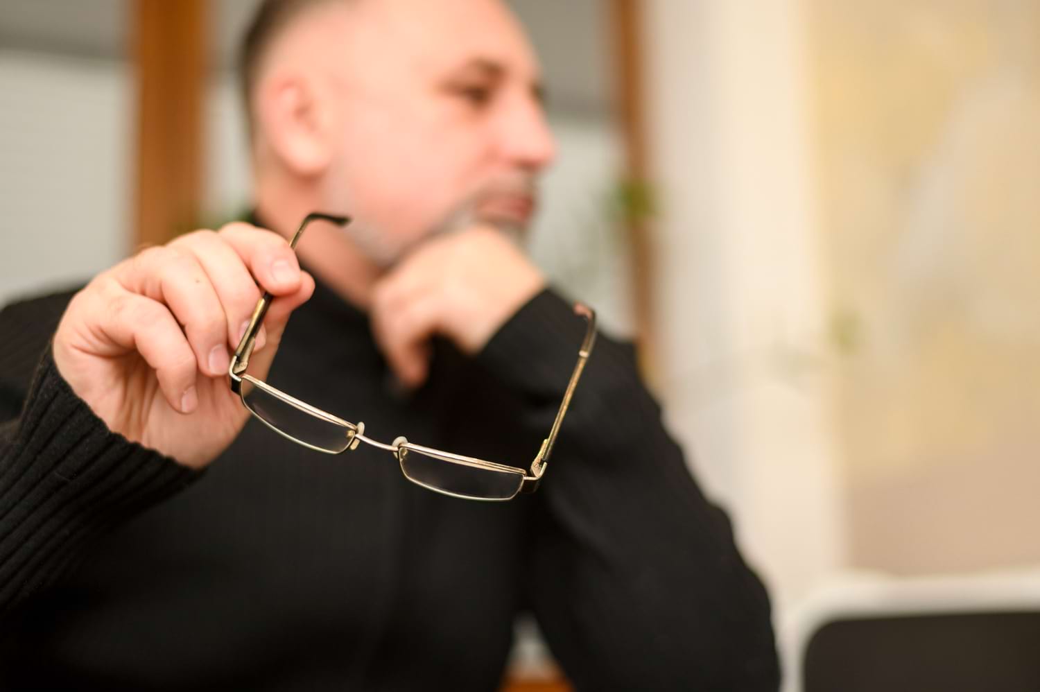 Homme tient des lunettes dans ses mains