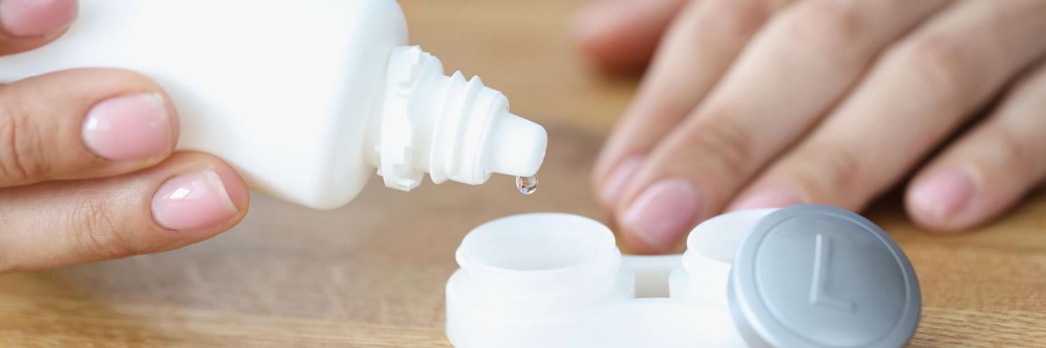 Femme met une solution dans une boîte à lentilles